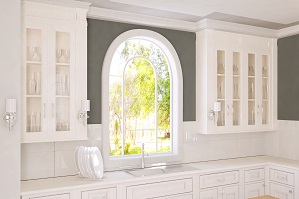 A curved picture window in a kitchen area above a sink